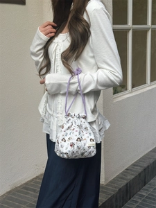 Detailed shot of a quilted drawstring pouch with cartoon prints held by a model