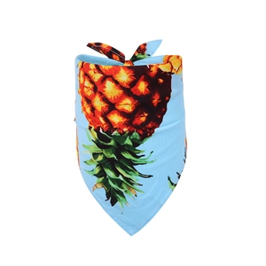 Macro detail of sky blue cotton dog bandana with vibrant pineapple fruit patterns