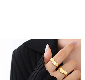 Detailed view of two 18K gold plated C-shaped earrings with textured wavy design