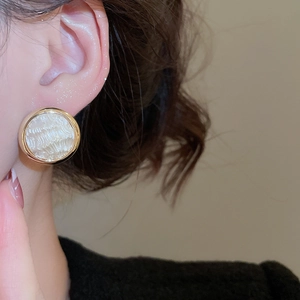 Dettaglio di eleganti orecchini placcati oro 16K con texture perla vintage e bordo oro