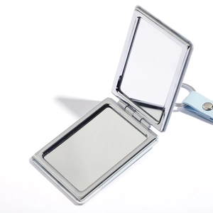 Macro view of portable silver metal folding mirror with a light blue leather keychain strap