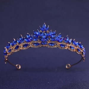 Detailed close-up of golden bridal tiara with blue marquise gems and clear rhinestones
