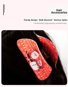 Detailed view of a red Christmas hair claw clip with festive Santa and reindeer patterns
