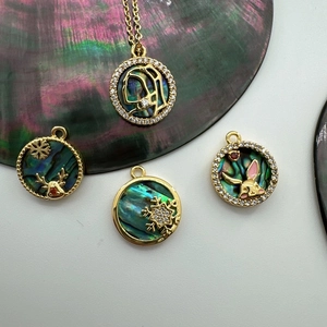 Detail of 18K gold plated charms featuring Mother Mary, snowflake and rabbit motifs