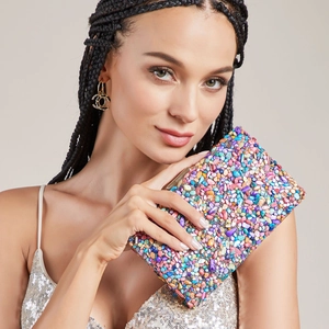 Pochette de soirée en cristal coloré avec cadre métallique tenue par mannequin