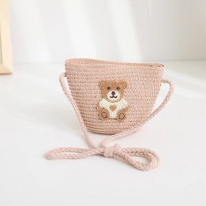 Detail of pink woven straw crossbody bag for kids with cute teddy bear embroidery