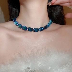 Detail of a choker necklace with blue gradient rhinestones worn on a model's neck