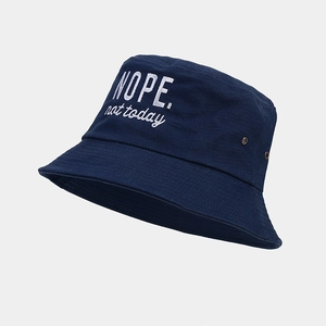 Close-up of white embroidery and metal air vents on a navy cotton bucket hat