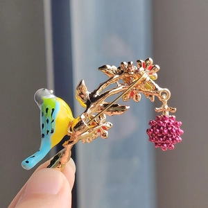 Pastoral style bird brooch with raspberry pendant and colorful enamel wings