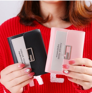Detail of bifold women's wallets with texture, color blocking, and metallic G-buckle