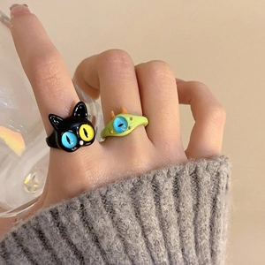Detail of colorful resin rings featuring cute cartoon cat and green monster designs