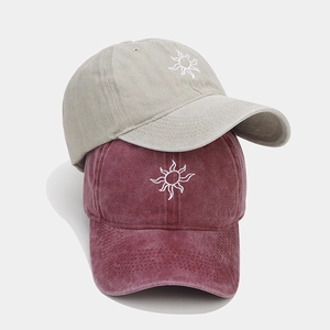 Detail of washed cotton baseball caps with sun embroidery and retro vintage texture