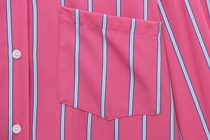 Detailed macro view of striped shirt pocket with white buttons and precise stitching