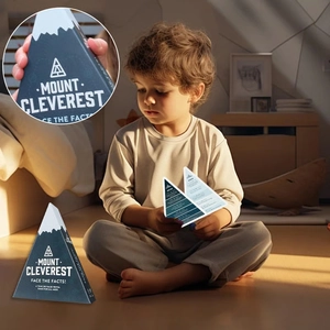 A young boy playing the Mount Cleverest trivia card game on an indoor floor setting