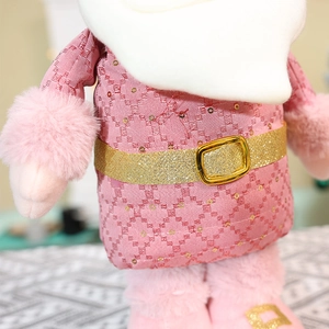 Detailed view of pink Christmas plush doll with shimmering gold sequin belt and faux fur