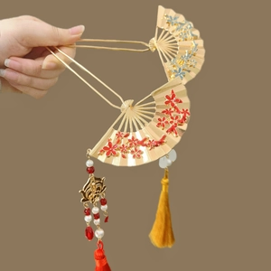 Detail of two golden fan-shaped hairpins with enamel flowers and long bead tassels