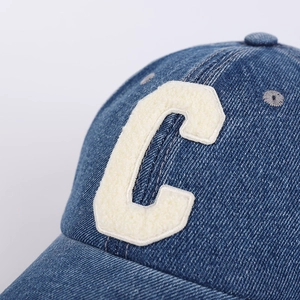 Detailed view of the navy denim baseball cap with white chenille C letter embroidery