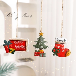 Three rustic Christmas ornaments featuring Santa, a tree, and a sock with hemp ropes