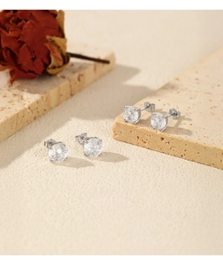Vue macro de boucles d'oreilles rondes étincelantes en argent sterling S925 à quatre griffes