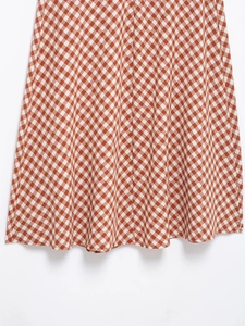 Detailed view of red and white gingham seersucker fabric with pleated texture detail
