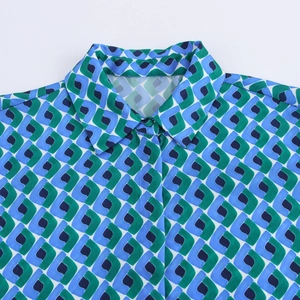 Détail du col à revers et de l'épaule sur la chemise à motifs géométriques bleus
