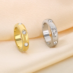 Detail of gold and silver stainless steel rings with round crystal inlay on soft fabric