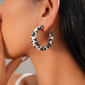 Detail showing model wearing large zebra print wrapped C-shape hoop earrings in retro style