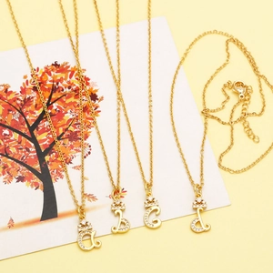 Detail of golden crown initial necklaces A to D with sparkling cubic zirconia inlay