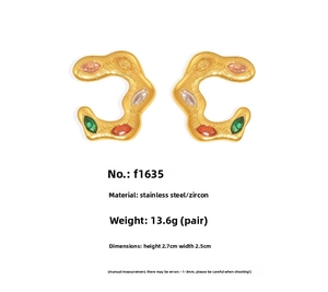 Macro detail of gold C-shaped twisted earrings with colorful marquise zircon stones