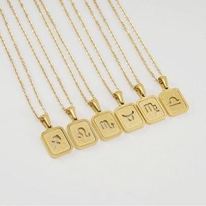 Détail de colliers zodiaque plaqués or 18 carats avec pendentifs rectangulaires mats