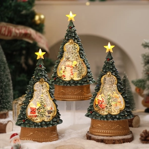 Close-up of three glowing Christmas tree snow globes with Santa Claus and snowman figures