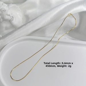Detailed view of 0.6mm gold-plated silver snake chain necklace with spring ring clasp