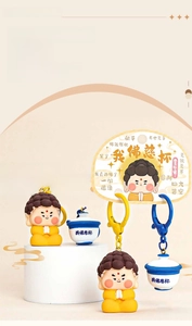 Detail of funny Buddha figure keychain with creative porcelain cup accessory and card