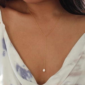 Close-up of elegant gold Y-shaped sterling silver necklace with a round pearl pendant