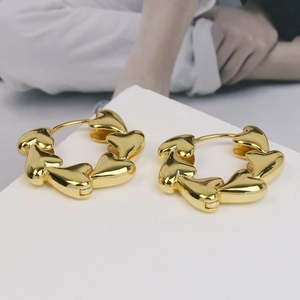 Elegant 18k gold plated brass heart hoop earrings displayed on a white minimalist pedestal