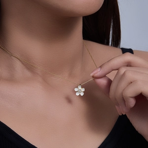 Detail of s925 silver necklace with white flower pendant and zircon on a female model
