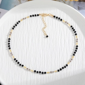 Handmade beaded necklace with black and grey faceted natural stones and gold spacers