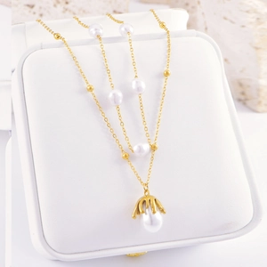 Elegant gold chain necklace with layered white pearls and liquid metal pendant accent