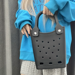 Detail of waterproof black EVA beach tote with round vent holes and silver rivets
