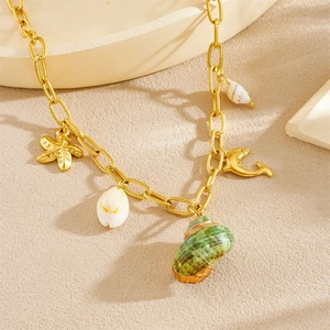 Gold ocean necklace with starfish, seashell, conch and dolphin pendants on sand background