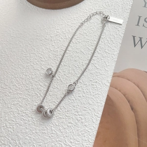 Macro detail of S925 sterling silver chain with zircon beads on a minimalist background
