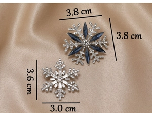 Detail view of blue and white rhinestone snowflake brooches with exact size dimensions
