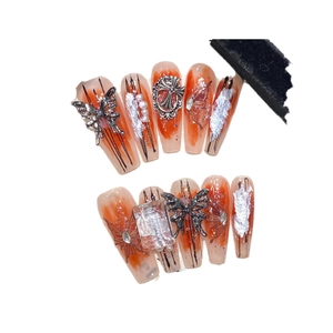 Faux ongles faits main avec marbrures rouges, papillon argenté et éclats de cristal