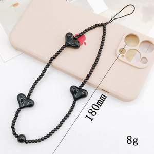 Black beaded phone wrist strap with heart charms next to a pink case 180mm 8g