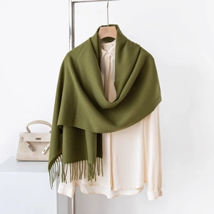 Dettaglio di una morbida sciarpa verde effetto cashmere con frange su una camicia