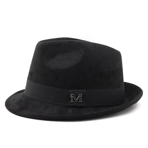 Detail of black fedora hat featuring a silver metal M logo on the ribbed band
