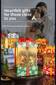 Close-up of a Christmas gift box lantern with interior holiday scene and falling snow
