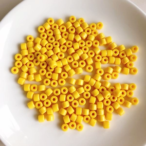 Macro shot of bright yellow cylindrical acrylic beads for DIY jewelry crafting accessories