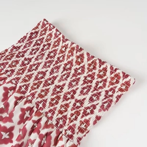 Détail de la taille élastique froncée sur un ensemble jupe longue à motifs rouge et blanc