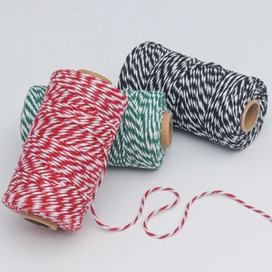 Detailed view of red, green and black baker's twine on kraft rolls for gift wrapping